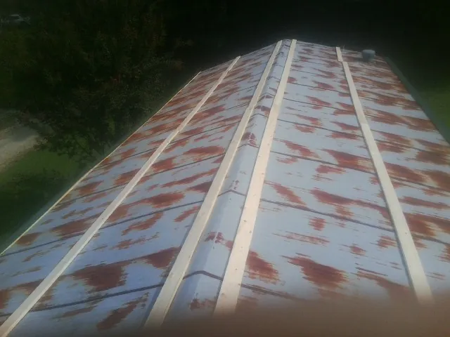Rusted metal roof panels with new wood purlins before replacement — Storm Damage Roof Repair in De Beque by Roofing Brothers